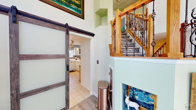 356 S Littler Dr, Pueblo West, CO 81007 - corridor with a barn door, wood finished floors, and stairs
