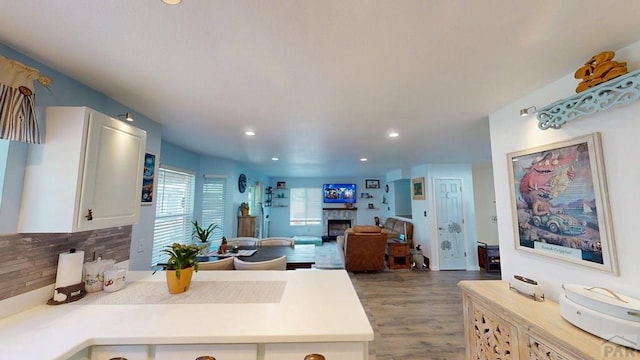 356 S Littler Dr, Pueblo West, CO 81007 - kitchen with a fireplace, backsplash, light countertops, wood finished floors, and white cabinetry