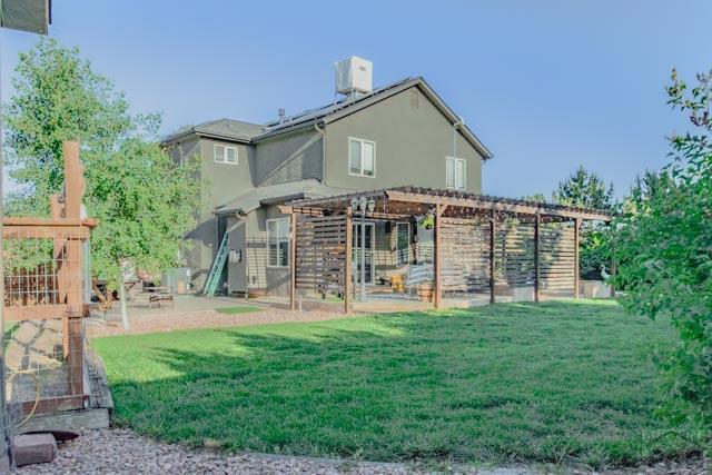 356 S Littler Dr, Pueblo West, CO 81007 - rear view of house with a pergola, a lawn, a patio area, and stucco siding