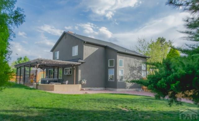 356 S Littler Dr, Pueblo West, CO 81007 - back of property with a pergola, stucco siding, and a lawn