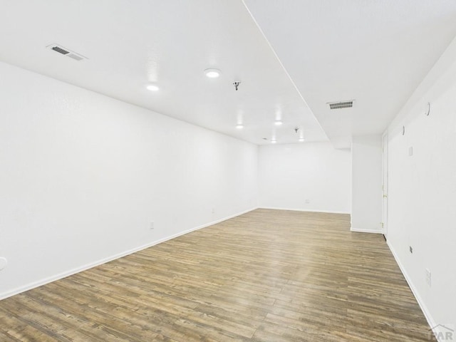 empty room with visible vents, baseboards, and wood finished floors