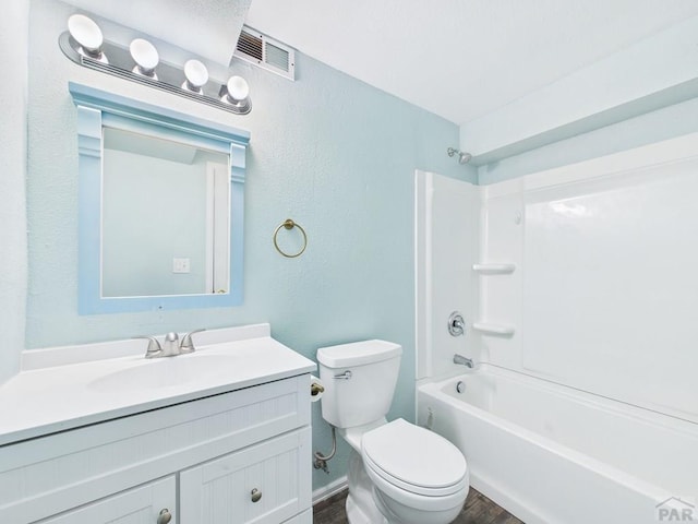 bathroom featuring visible vents, toilet, wood finished floors, shower / bathing tub combination, and vanity