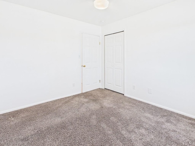 carpeted empty room featuring baseboards