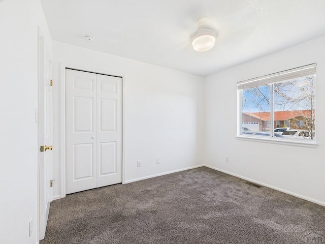 unfurnished bedroom with a closet, baseboards, visible vents, and carpet floors