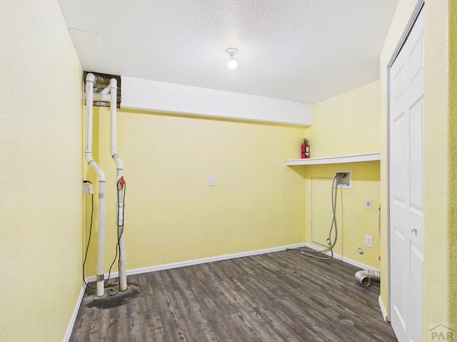 washroom featuring hookup for a washing machine, wood finished floors, baseboards, laundry area, and a textured ceiling