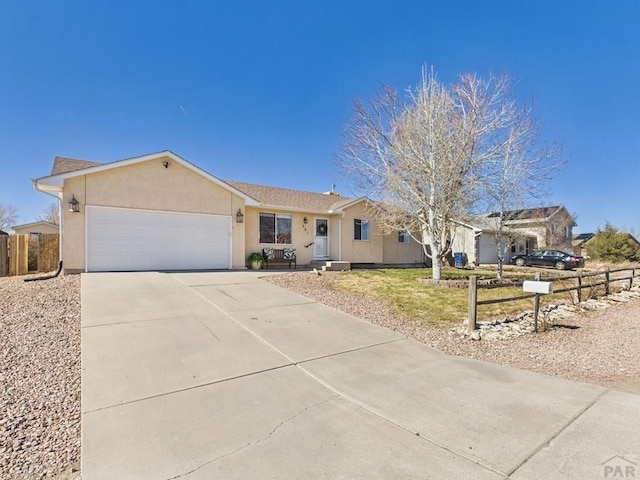 ranch-style house with stucco siding, driveway, an attached garage, and fence