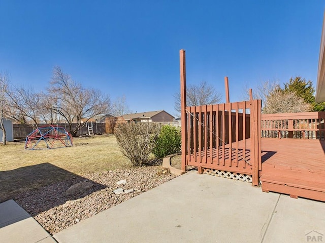 view of yard featuring a fenced backyard, a deck, and a playground