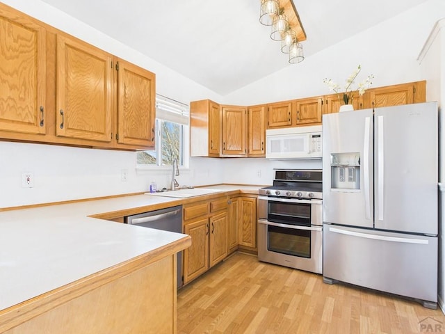 kitchen with double oven range, white microwave, a sink, light countertops, and fridge with ice dispenser