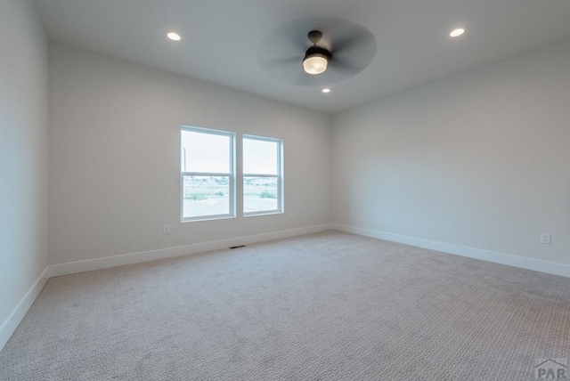 spare room featuring baseboards, light colored carpet, a ceiling fan, and recessed lighting