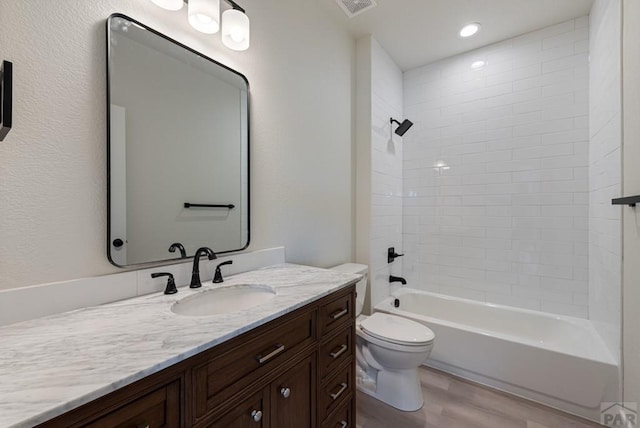 bathroom with shower / bathtub combination, recessed lighting, toilet, vanity, and wood finished floors