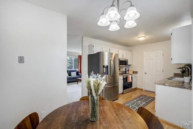 20 N 32nd St, Colorado Springs, CO 80904 - dining space featuring a chandelier and light wood-style flooring