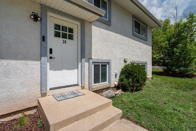 20 N 32nd St, Colorado Springs, CO 80904 - view of exterior entry featuring stucco siding and a lawn
