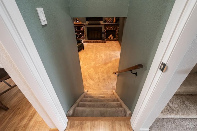 20 N 32nd St, Colorado Springs, CO 80904 - staircase featuring wood finished floors, a fireplace, and a textured wall