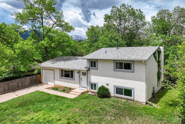 20 N 32nd St, Colorado Springs, CO 80904 - tri-level home with concrete driveway, a garage, a shingled roof, and stucco siding