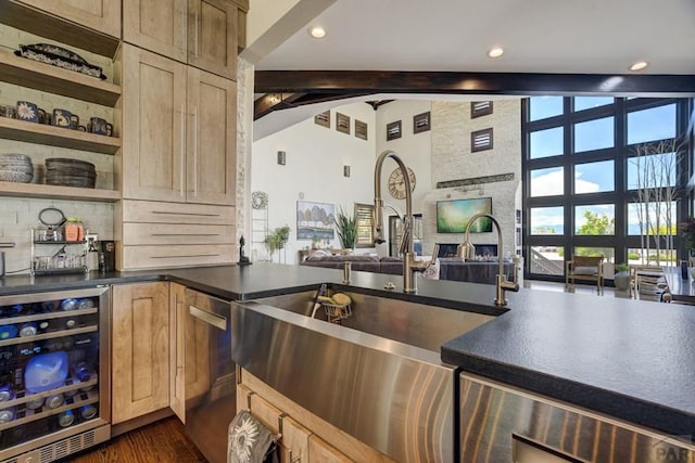 489 S Pin High Dr, Pueblo West, CO 81007 - kitchen featuring beverage cooler, dark countertops, open floor plan, beam ceiling, and a sink