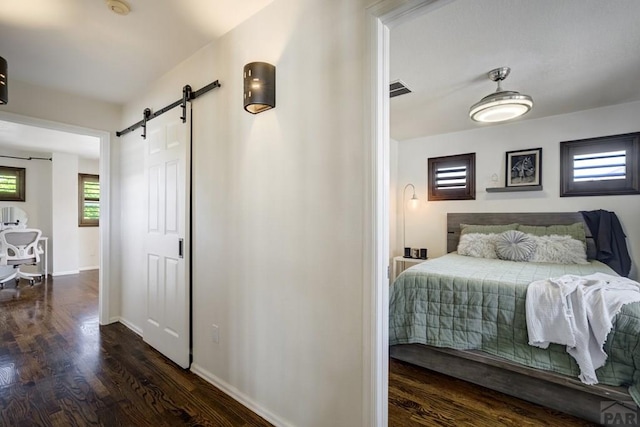 489 S Pin High Dr, Pueblo West, CO 81007 - bedroom with a barn door, wood finished floors, and baseboards