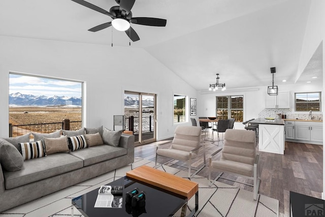 31 Bess St, Westcliffe, CO 81252 - living room featuring light wood finished floors, a mountain view, high vaulted ceiling, and ceiling fan with notable chandelier
