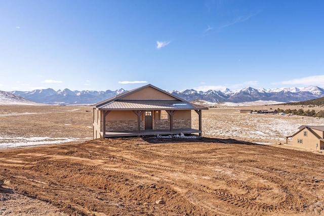31 Bess St, Westcliffe, CO 81252 - view of front of house featuring stone siding, a rural view, a mountain view, and stucco siding