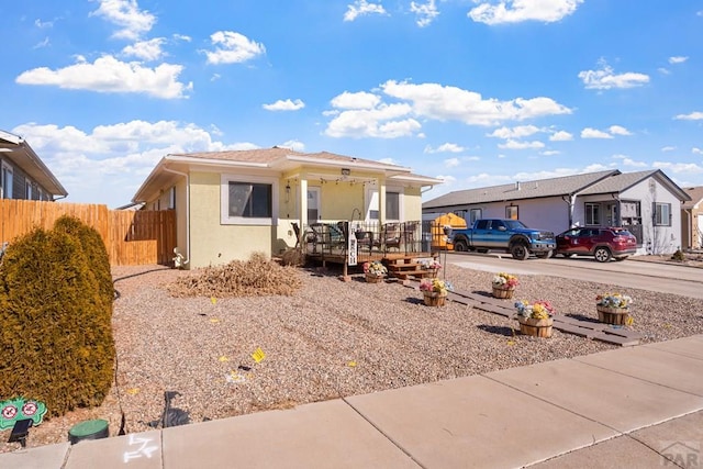 view of front of home with a porch, fence, and stucco siding