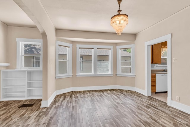 2121 N Greenwood St, Pueblo, CO 81003 - unfurnished dining area with wood finished floors, a chandelier, and healthy amount of natural light