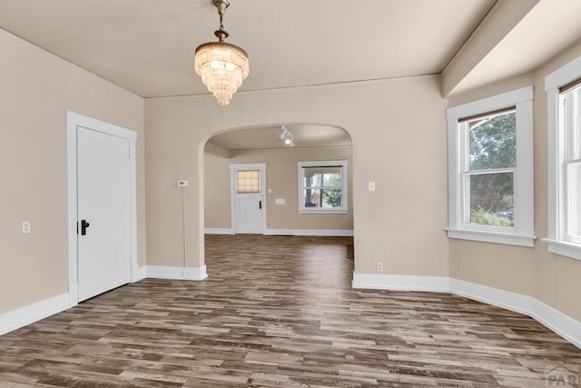 2121 N Greenwood St, Pueblo, CO 81003 - spare room with arched walkways, wood finished floors, and a chandelier