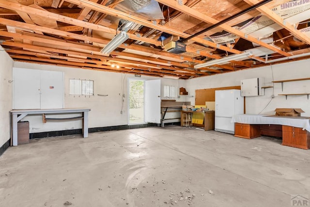 2121 N Greenwood St, Pueblo, CO 81003 - garage featuring a workshop area, freestanding refrigerator, and a garage door opener