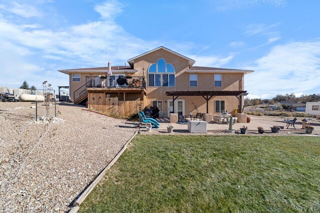 rear view of property featuring stucco siding, a lawn, stairway, a patio area, and a deck