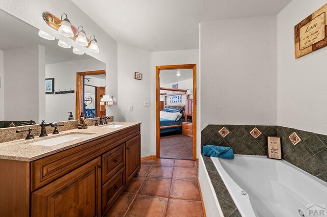 ensuite bathroom featuring double vanity, ensuite bath, a sink, and a bath