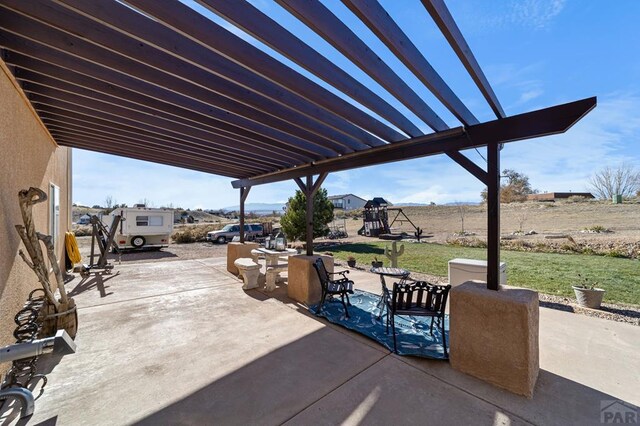 view of patio featuring a playground and a pergola