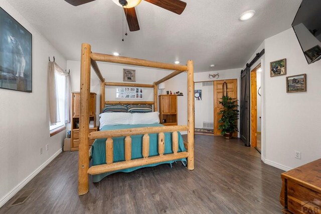 bedroom featuring a barn door, baseboards, dark wood-type flooring, and recessed lighting