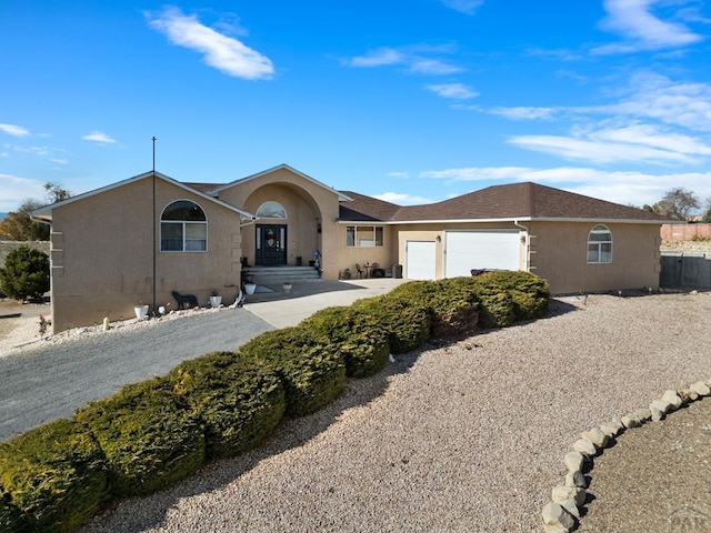 ranch-style home featuring a garage, roof with shingles, and stucco siding