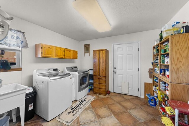 laundry room featuring independent washer and dryer, a sink, and cabinet space