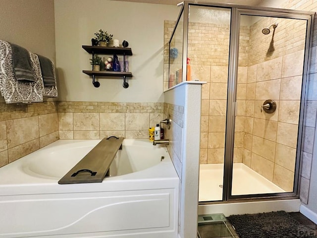 bathroom featuring a garden tub and a shower stall