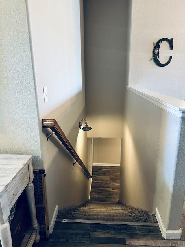 stairway with baseboards and wood finished floors