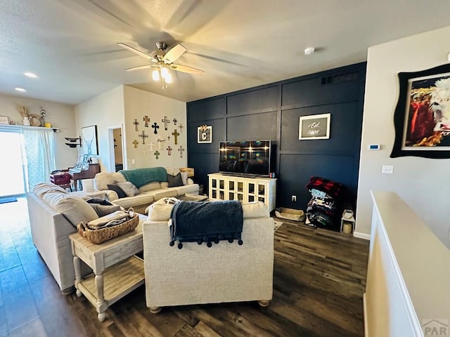 living room with ceiling fan and dark wood-type flooring