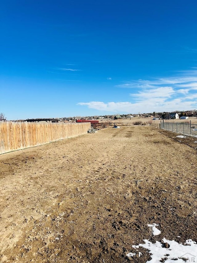 view of yard featuring fence and a rural view