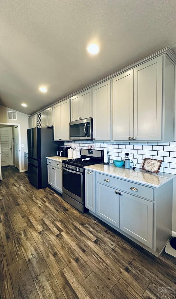 kitchen with recessed lighting, dark wood-style flooring, visible vents, appliances with stainless steel finishes, and tasteful backsplash