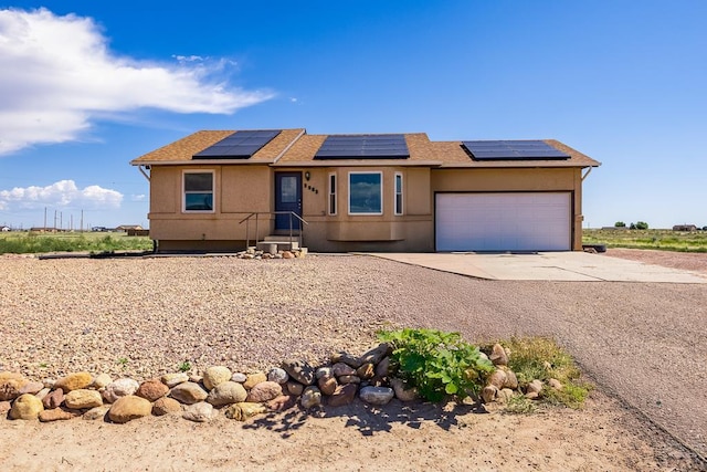 1085 E Blackstone Dr, Pueblo West, CO 81007 - single story home featuring concrete driveway, a garage, solar panels, and stucco siding