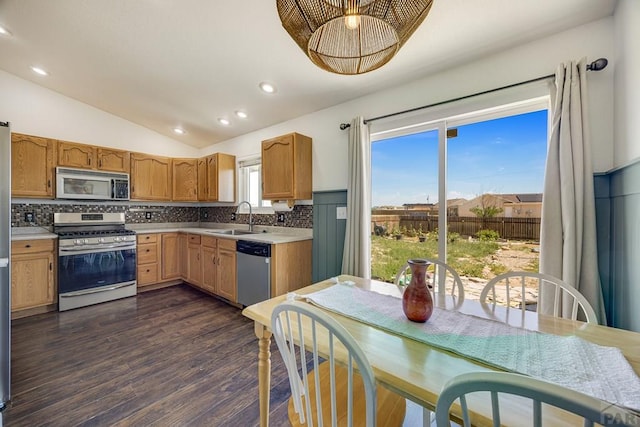 1085 E Blackstone Dr, Pueblo West, CO 81007 - kitchen with stainless steel appliances, lofted ceiling, decorative backsplash, dark wood-style floors, and light countertops