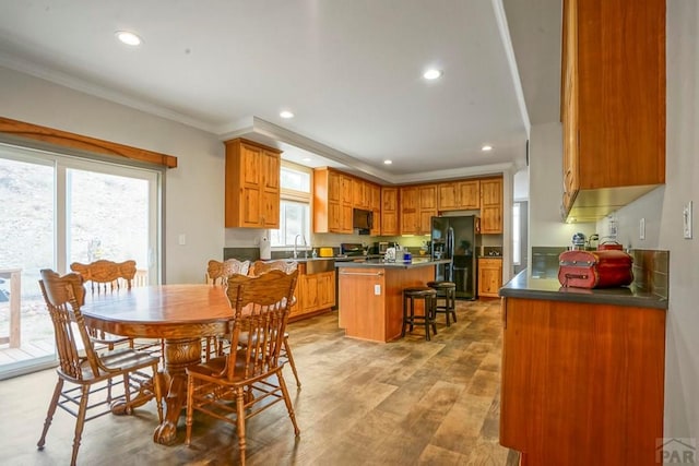 dining area featuring light wood finished floors, crown molding, and recessed lighting