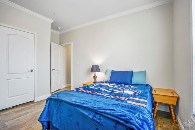 bedroom featuring crown molding, wood finished floors, and baseboards