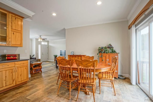 dining area with crown molding, a healthy amount of sunlight, and light wood-style floors