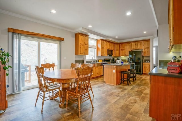 dining area featuring crown molding, light wood-style floors, and recessed lighting