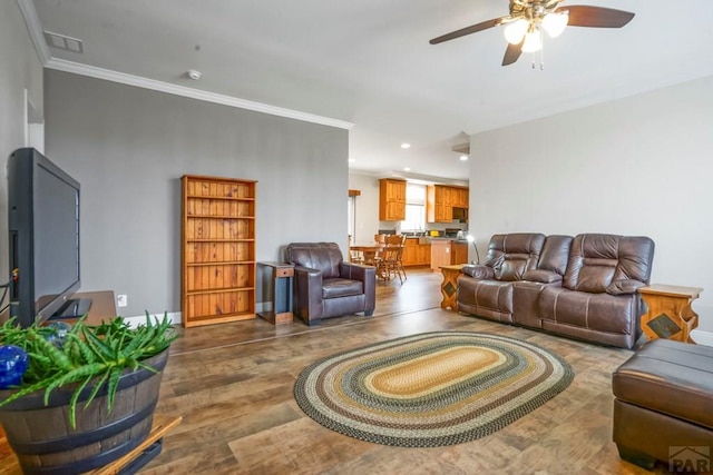 living area with wood finished floors, crown molding, visible vents, ceiling fan, and recessed lighting