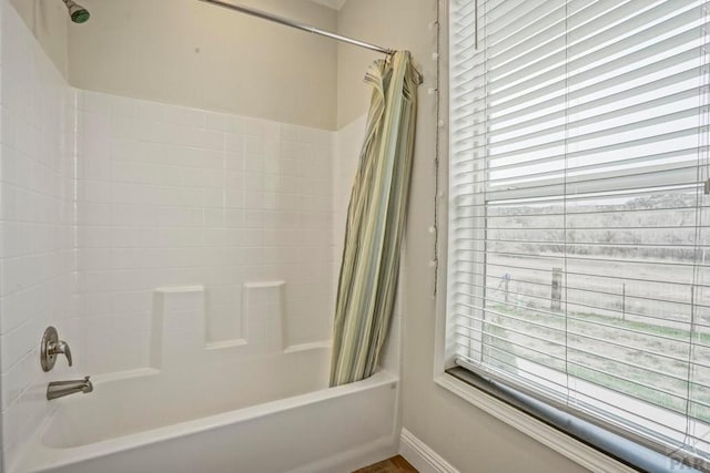 full bath with plenty of natural light, shower / tub combo, and baseboards