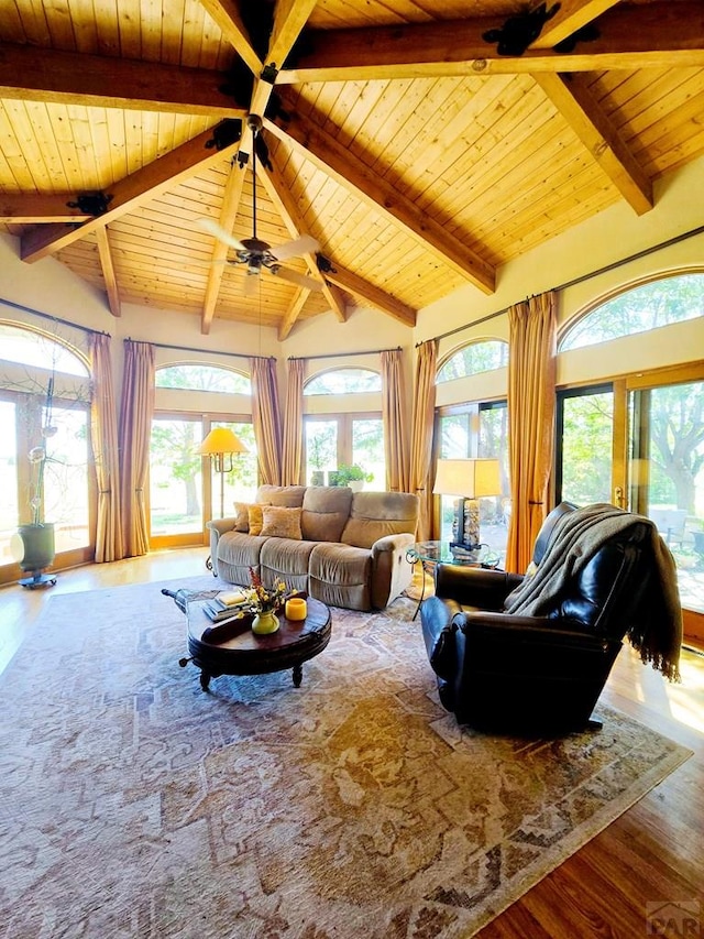 living room with a ceiling fan, wood ceiling, vaulted ceiling with beams, and wood finished floors