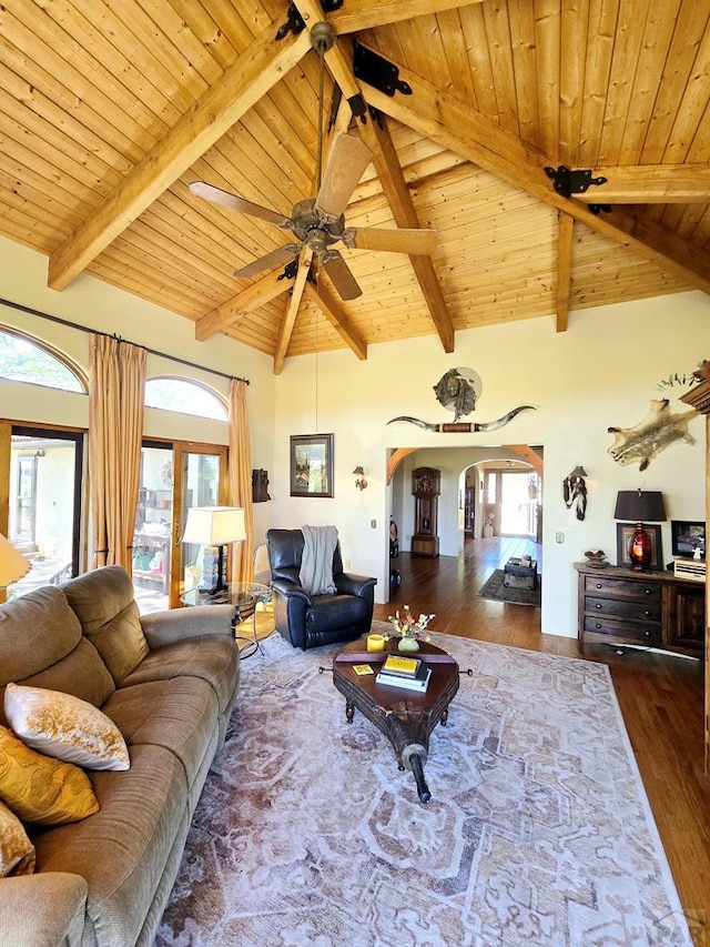 living room with arched walkways, wood ceiling, dark wood finished floors, and beam ceiling