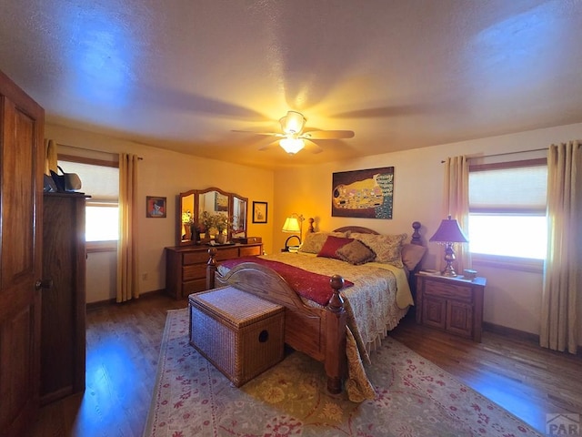 bedroom with ceiling fan, wood finished floors, and baseboards