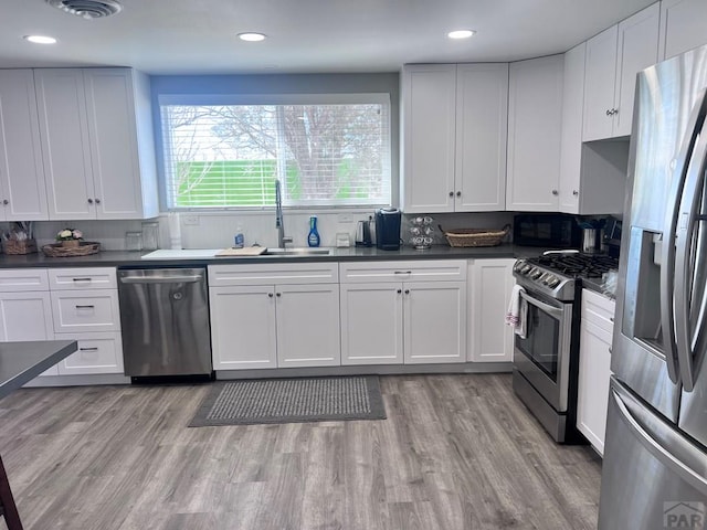 kitchen with light wood-style flooring, visible vents, appliances with stainless steel finishes, and a sink