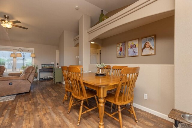 dining area featuring dark wood-style floors, ceiling fan, baseboards, and arched walkways